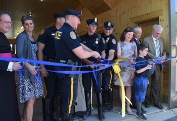 Msgr. William Baver, left, director of diocesan cemeteries, participated in the ribbon cutting of Quadrant Private Wealth Stable Facility, home of the Bethlehem Mounted Police horses at Holy Saviour Cemetery. (Photo by John Simitz)