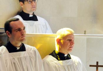 Seminarians Giuseppe Esposito, back, Matthew Kuna, front left, and John Maria listen as Father Mark Searles reflects on his vocation April 22 at St. Joseph the Worker, Orefield for World Day of Prayer for Vocations.